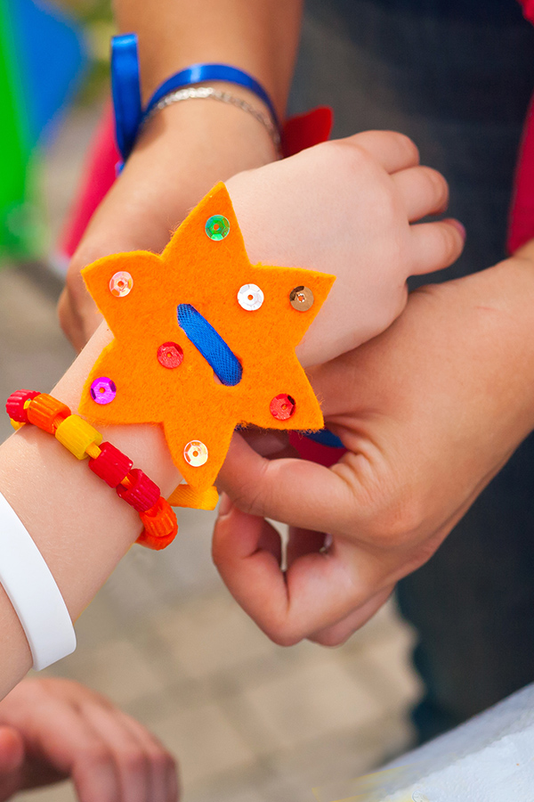 the creation of handmade jewelry made of felt, a bracelet is put on the child's hand